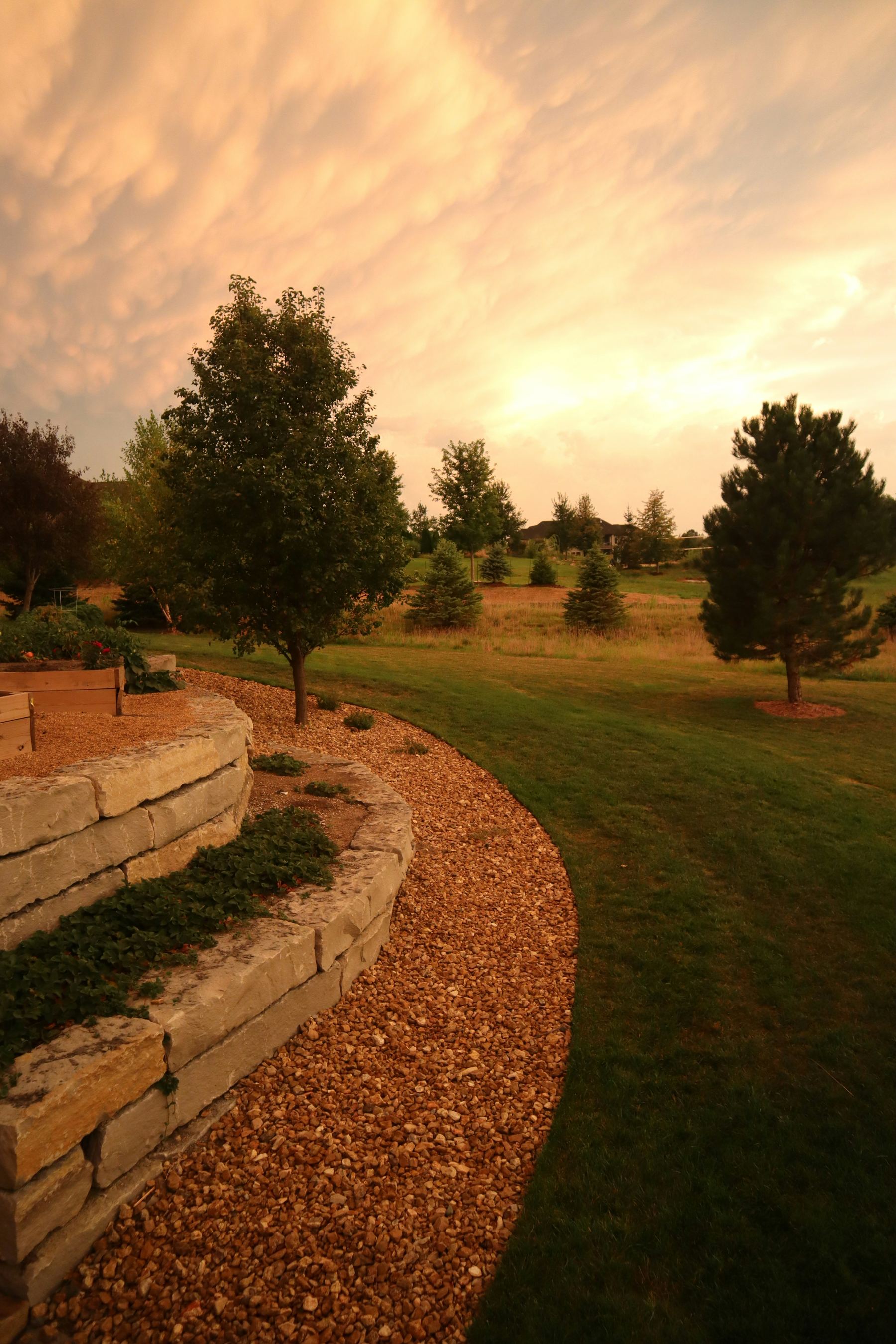 A well-kept landscaped yard with a stone retaining wall